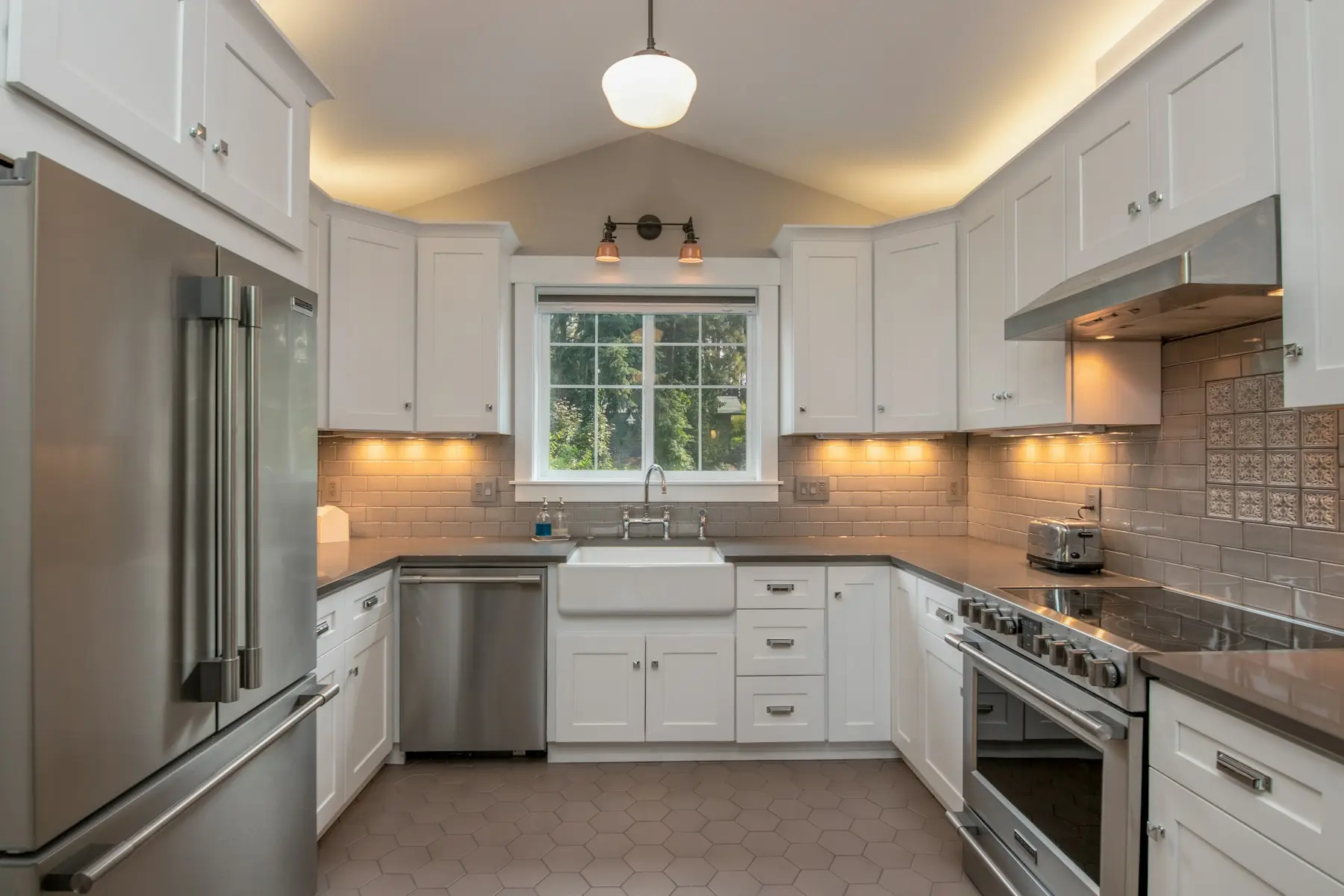 U-shaped kitchen with white cabinets and stainless appliances